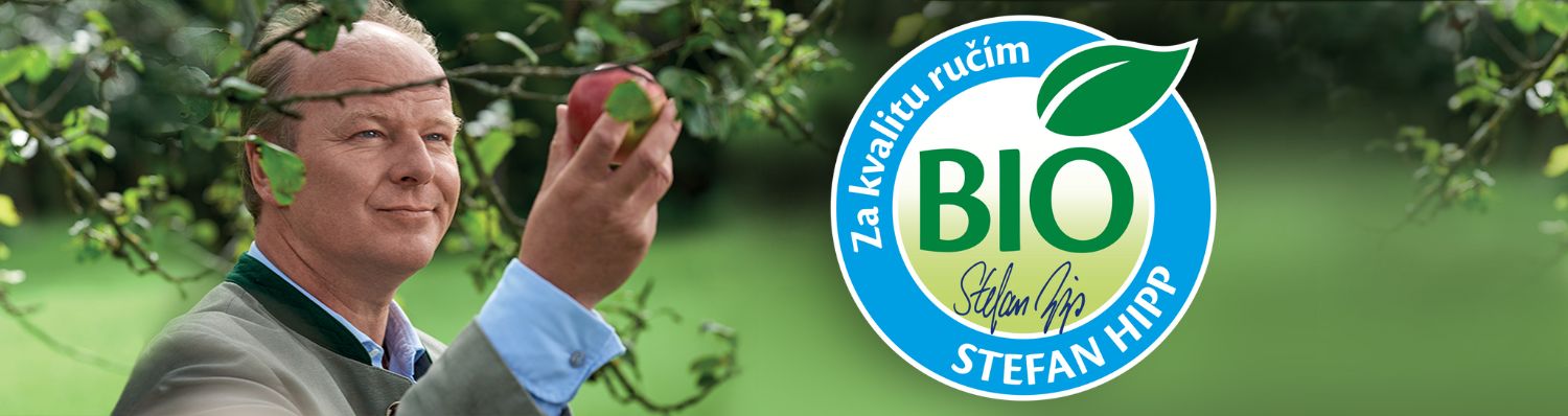 Muž v zelenej košeli drží červené jablko, v pozadí je kruhové logo s nápisom "BIO" a symbolom listu.